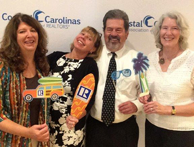 Sig with a group at the Coastal Carolina's realtors event in an informal setting with beach oriented props