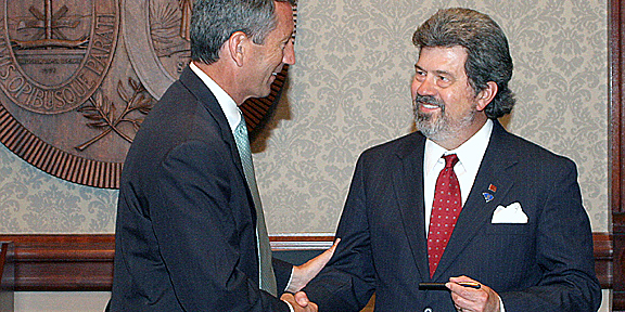Sig shaking hands after receiving award